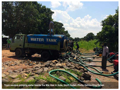Truck vendors pumping water beside the Nile river in Juba, South Sudan. Photo: Katrice King/Oxfam.