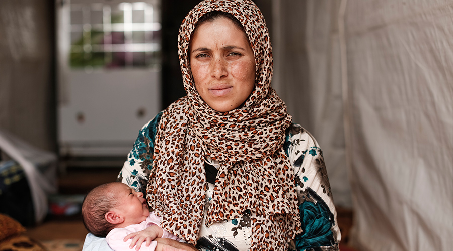Hanin 26, sit with her four week old baby Sana*, 4-weeks , in the tent in which they now live in an informal settlement for Syrian refugees in north Bekaa Valley in Lebanon on September 10 2015. Photo Credit: Sam Tarling / Oxfam