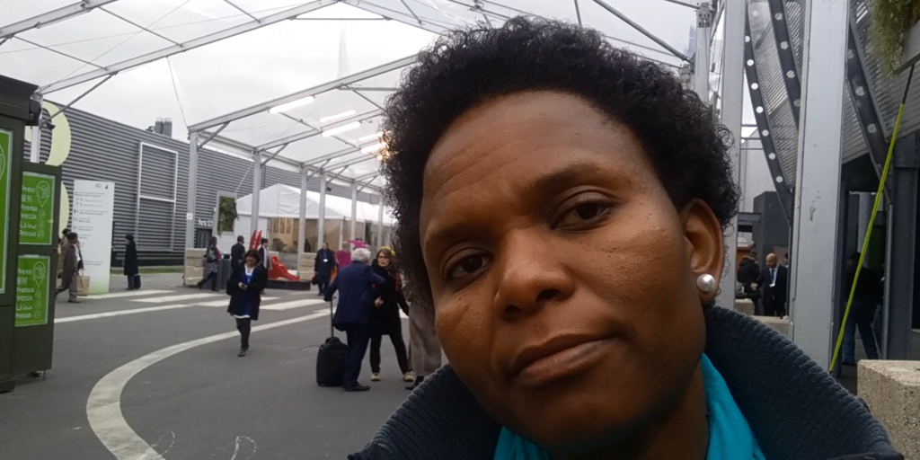  Dorah speaking to camera inside the conference centre at COP21