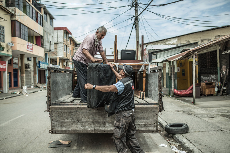 Luis Toral loads some of his belongings from a partially destroyed building into a truck in Portoviejo.