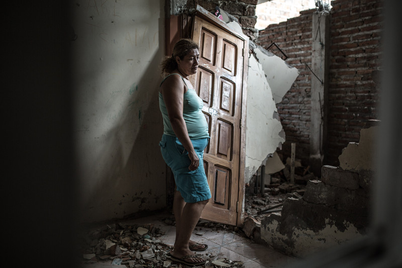 Alba stands in her ruined home that she shared with her husband Lenin, three of their children and their two year old granddaughter. 