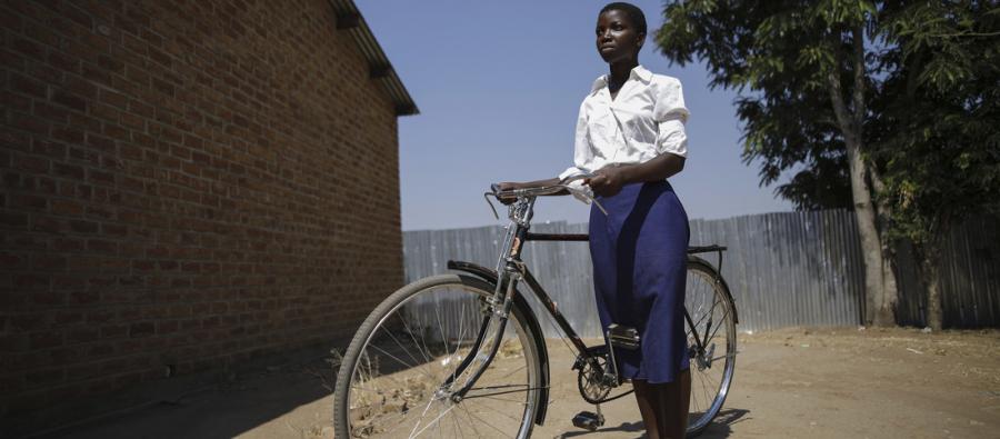 Alice stands with wher bike. She lives 20km away from school. It used to take her hours to walk to school. "The walk was a bad experience. I would go to school on Monday but then on a Tuesday I would be absent as I was so sick and tired. I would miss one day a week and go in four days. I forced myself to go. I was arriving at school so tired. I couldn't concentrate as had I no time to rest. I tried to work hard but I was just so tired," said Alice. Oxfam has so far provided bicycles to 30 girls in schools across Southern Malawi. Photo Credit: Corinna Kern