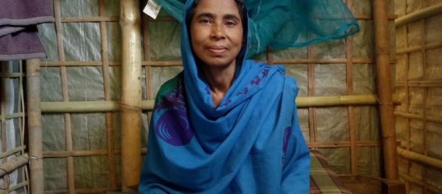 Woman wearing a blue head scarf looking at camera.