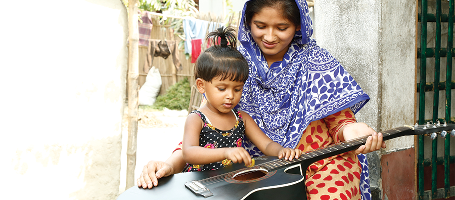 Rubina and her dauther play with a guitar.