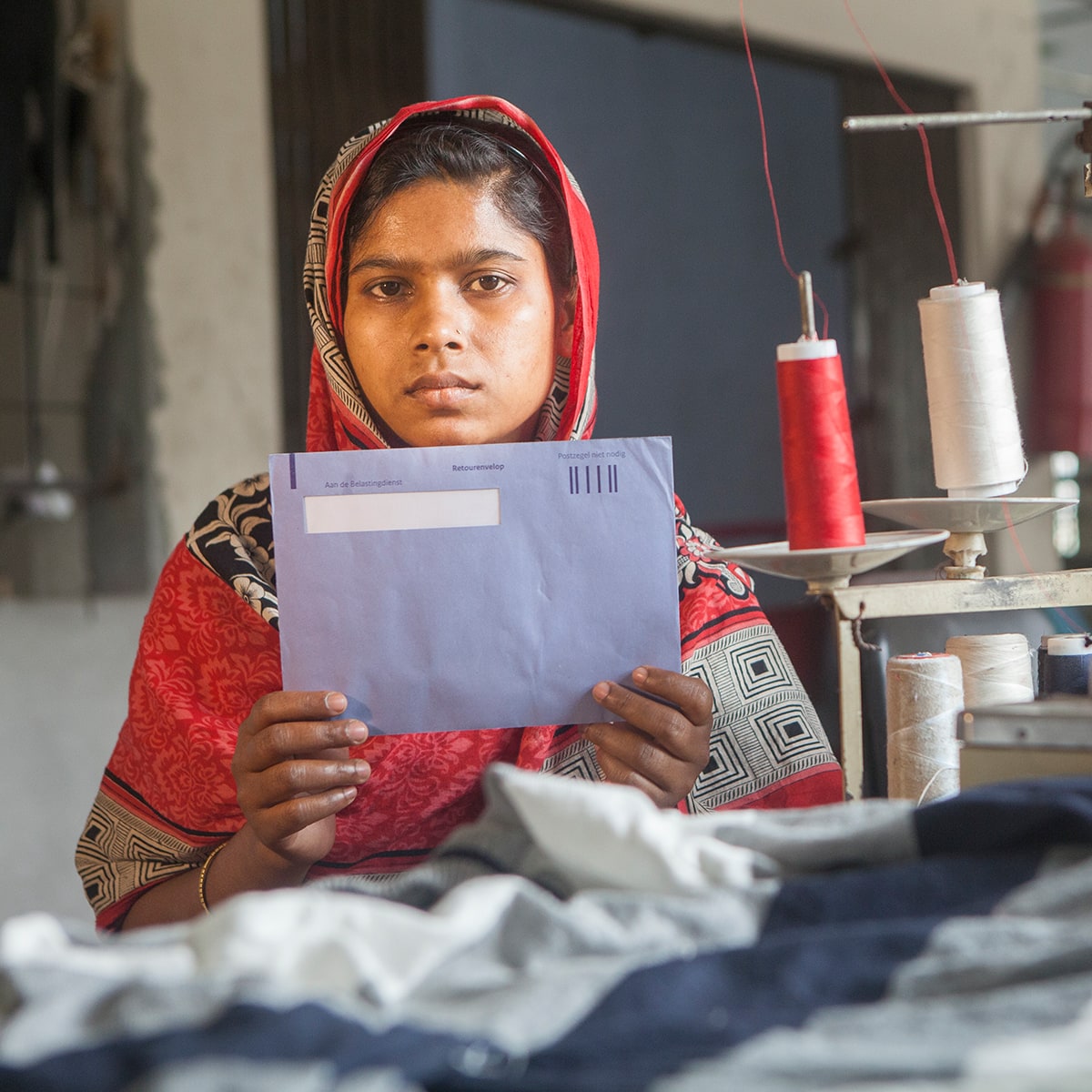 A young woman holding a blue tax envelope