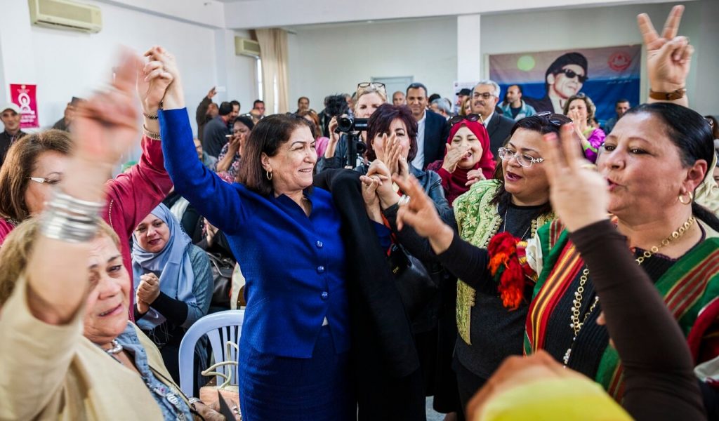 A group of men and women celebrate the election of the first woman to the executive board of UGTT.