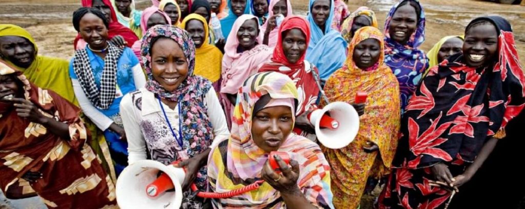 South Sudanese women who are chanting and speaking into megaphones