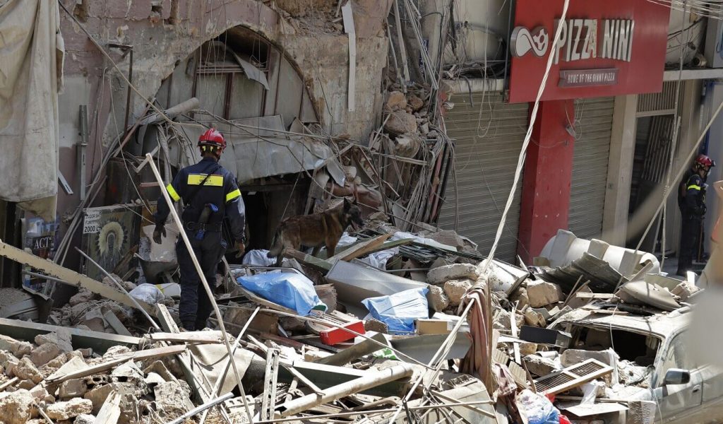 Firefighters work in the rubble and debris on a residential street in Beirut, Lebanon.
