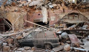 Rubble and debris sits on a damaged automobile on a residential street in Beirut, Lebanon.