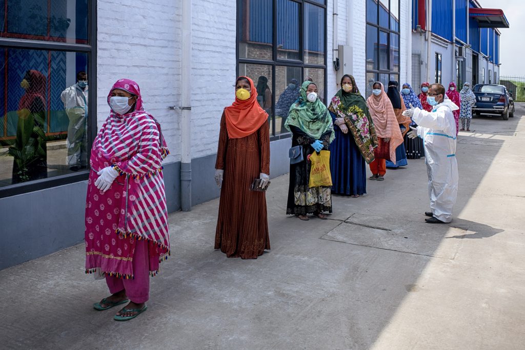 Women domestic workers stand in line at food distribution center set up by Nari Maitree.