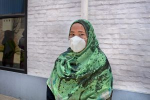 Mollika Begum wearing a green scarf and black dress.
