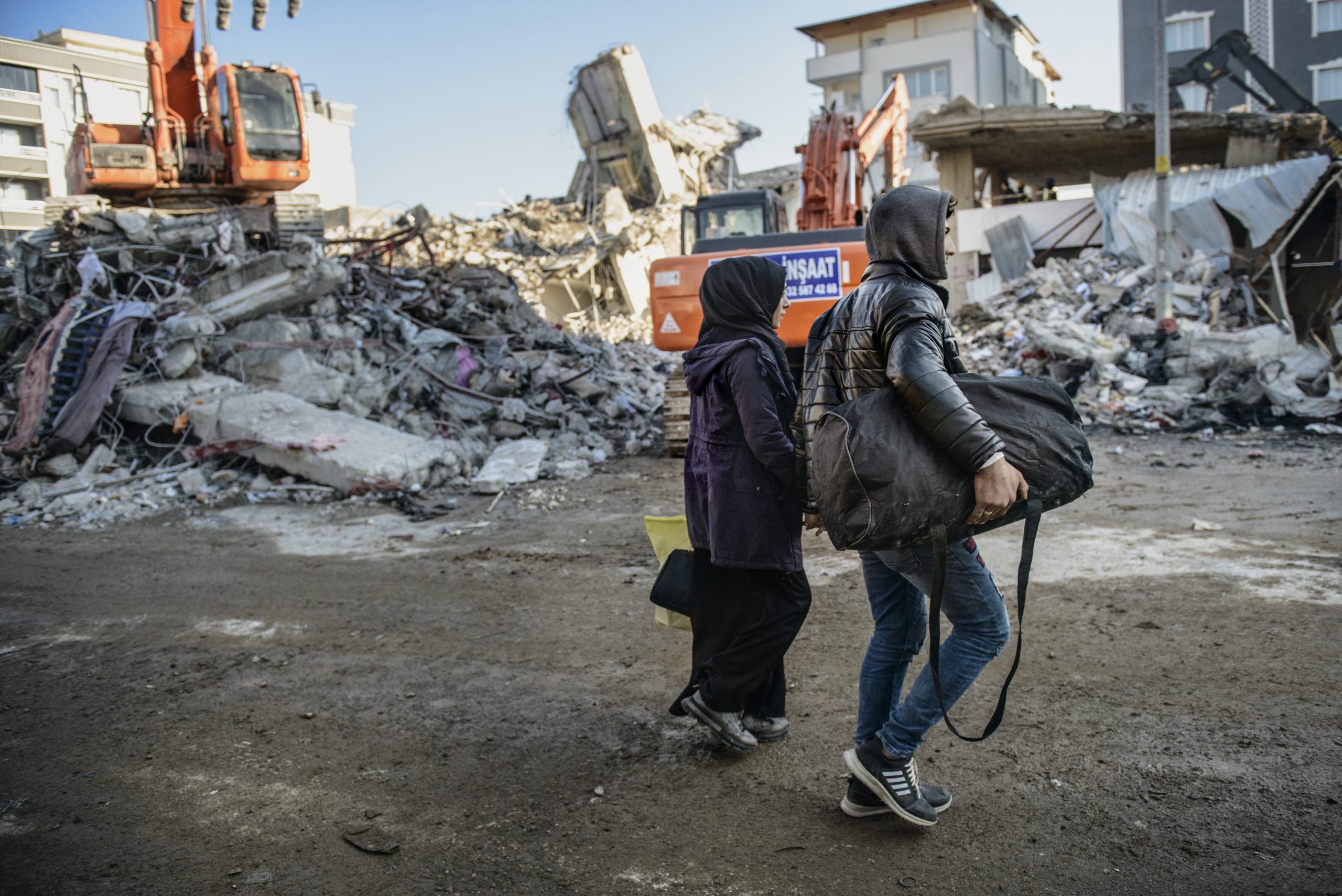 Two local residents gathering belongings from their destroyed home, before joining to the thousands of displaced survivors of the disaster.