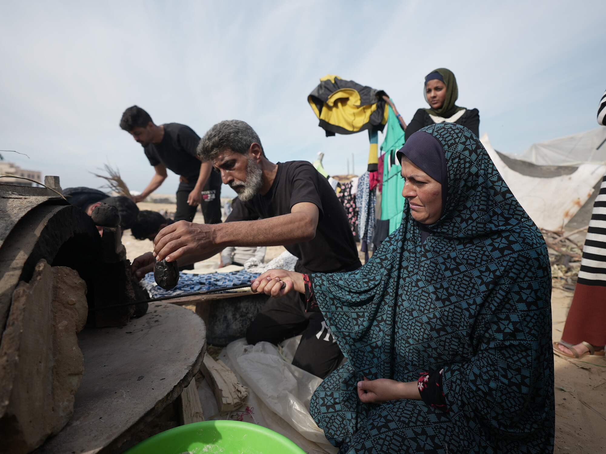 Mutaz* and his wife Muna* use the oven they made out of clay to make some bread.
