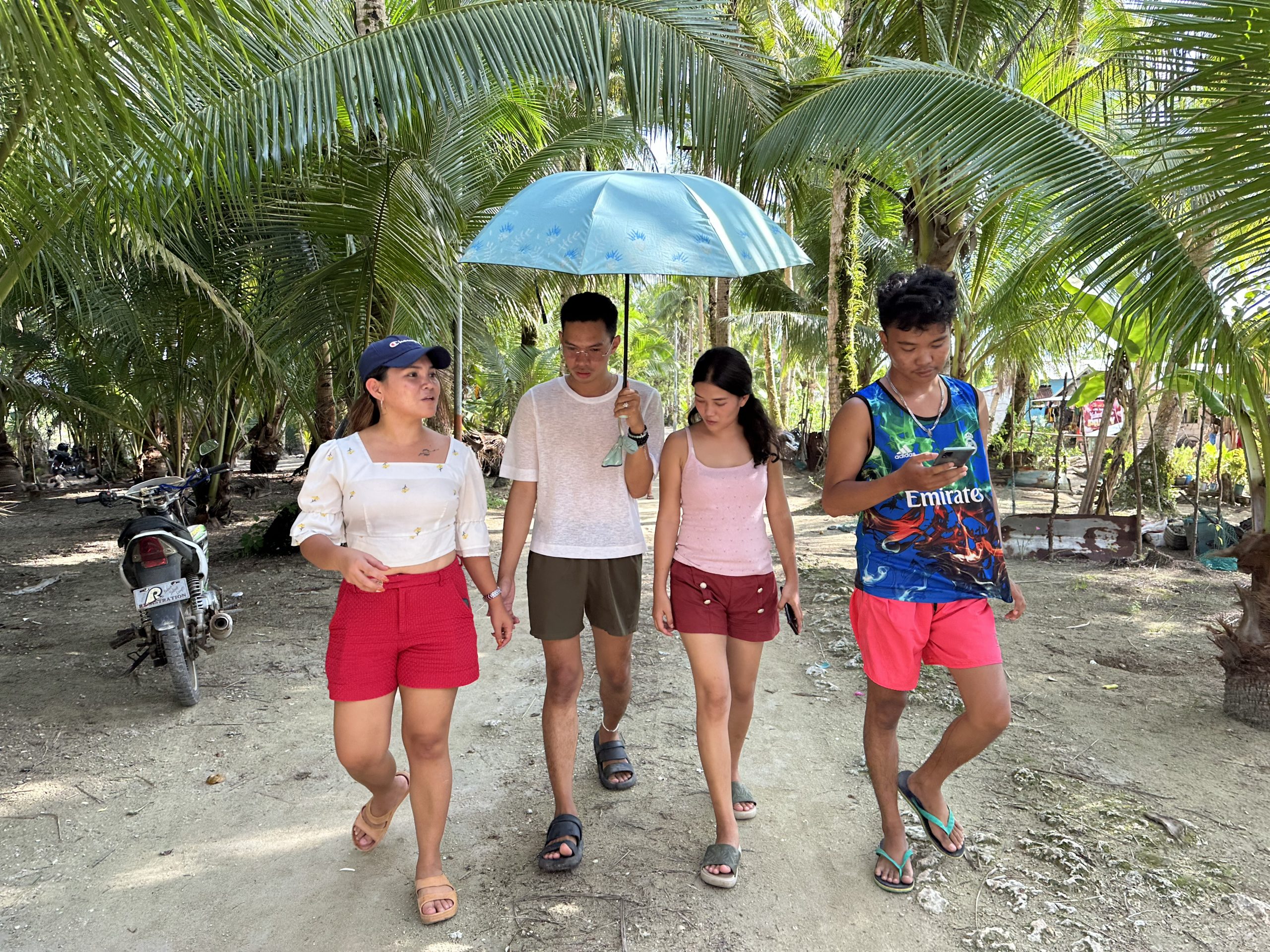 Oxfam InuruID 361139 Philippines 2023-08-19 Marinel with her old time school and activist friends, Ariel, Reynalda and John, walking through Matarinao. Photo: Stories4Change by Climate Tracker/Oxfam