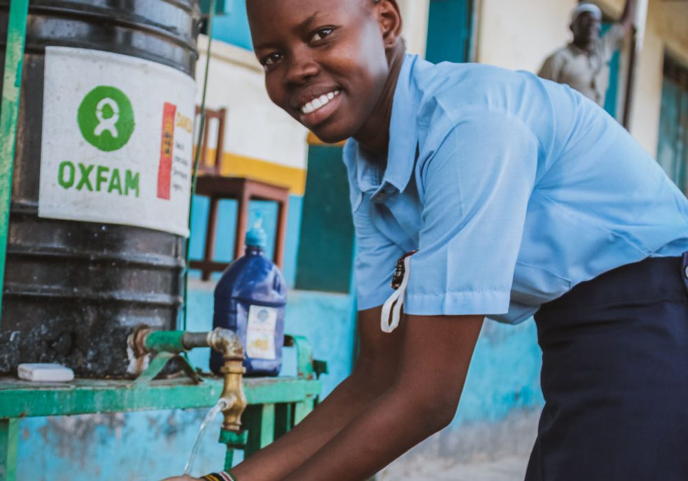 Oxfam and You_Hero1 A young woman washes her hands at an Oxfam handwashing station.
