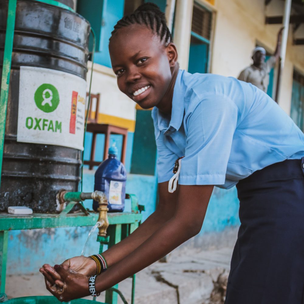 Oxfam and You_Hero1 A young woman washes her hands at an Oxfam handwashing station.