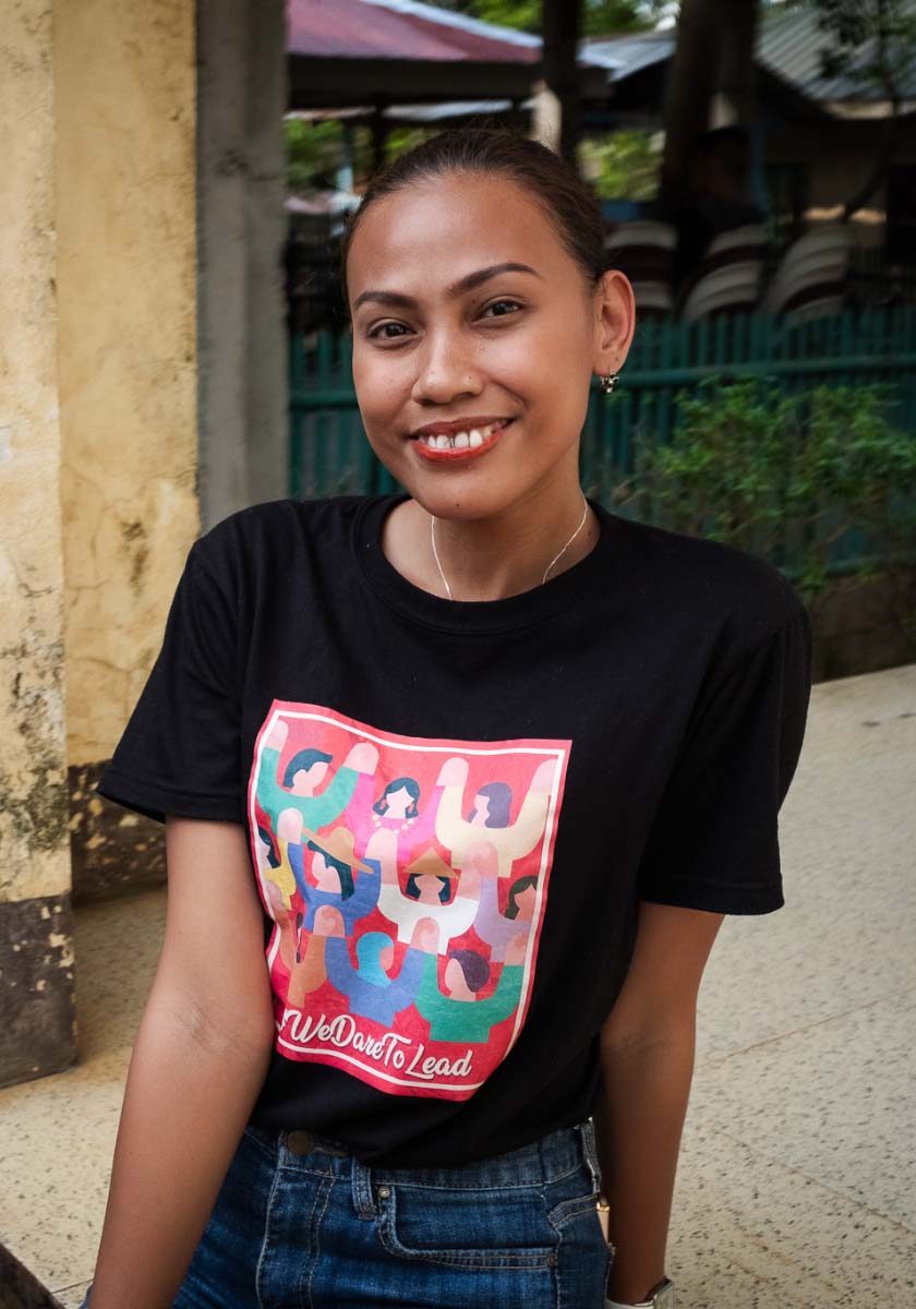 SexualReproductiveRights_Impact2 A smiling young woman faces the camera while wearing a shirt that reads ‘We Dare To Lead’.
