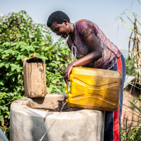 A man with a jerry can of water at a well.